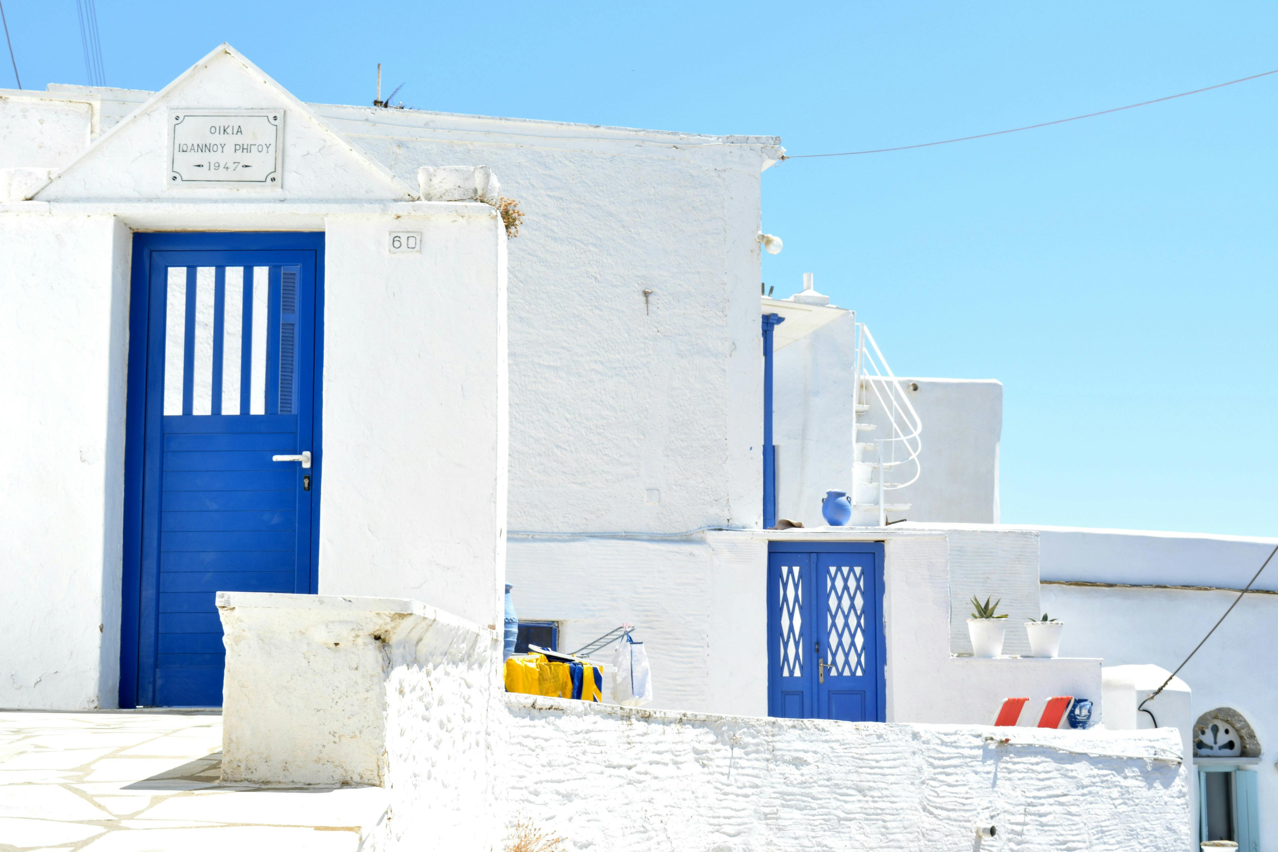 Traditional luxury white house with blue doors in Santorini, Greece by Urban Keys Real Estate