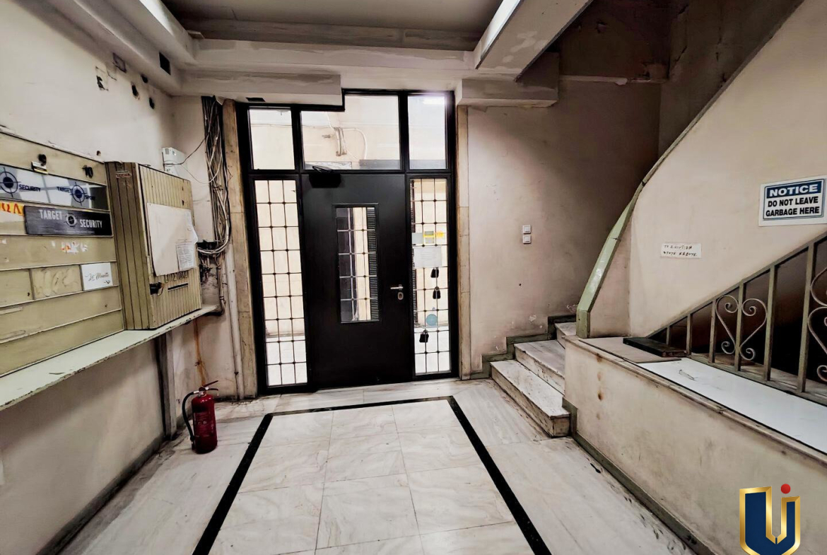 Ground-floor exit of the professional building leading to the internal arcade at 64 Ermou Street, Athens.