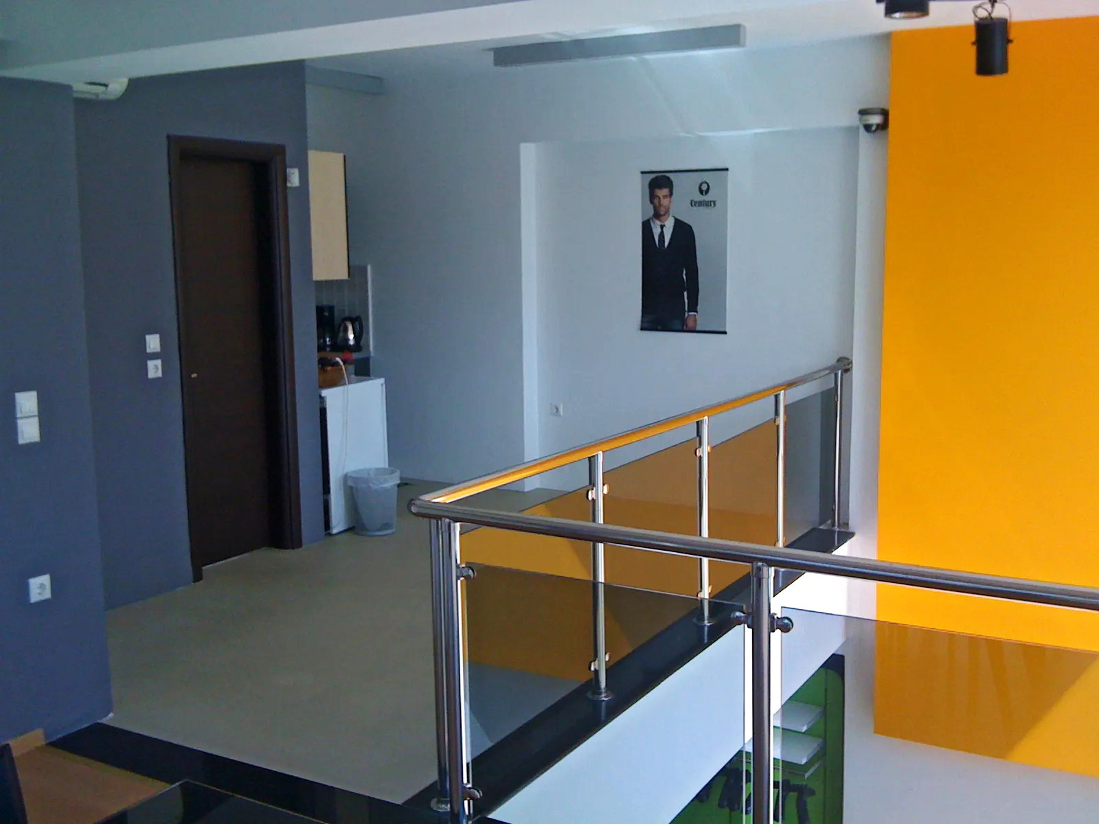 Mezzanine landing with glass-and-metal railing in a commercial building in Metamorfosi Mezzanine landing with glass-and-metal railing in a commercial building in Metamorfosi