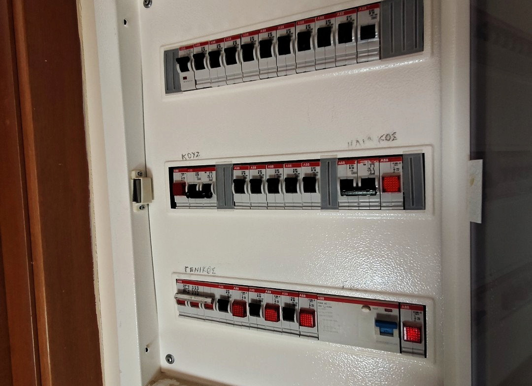 Wall-mounted electrical distribution panel with three rows of circuit breakers in a Paiania apartment