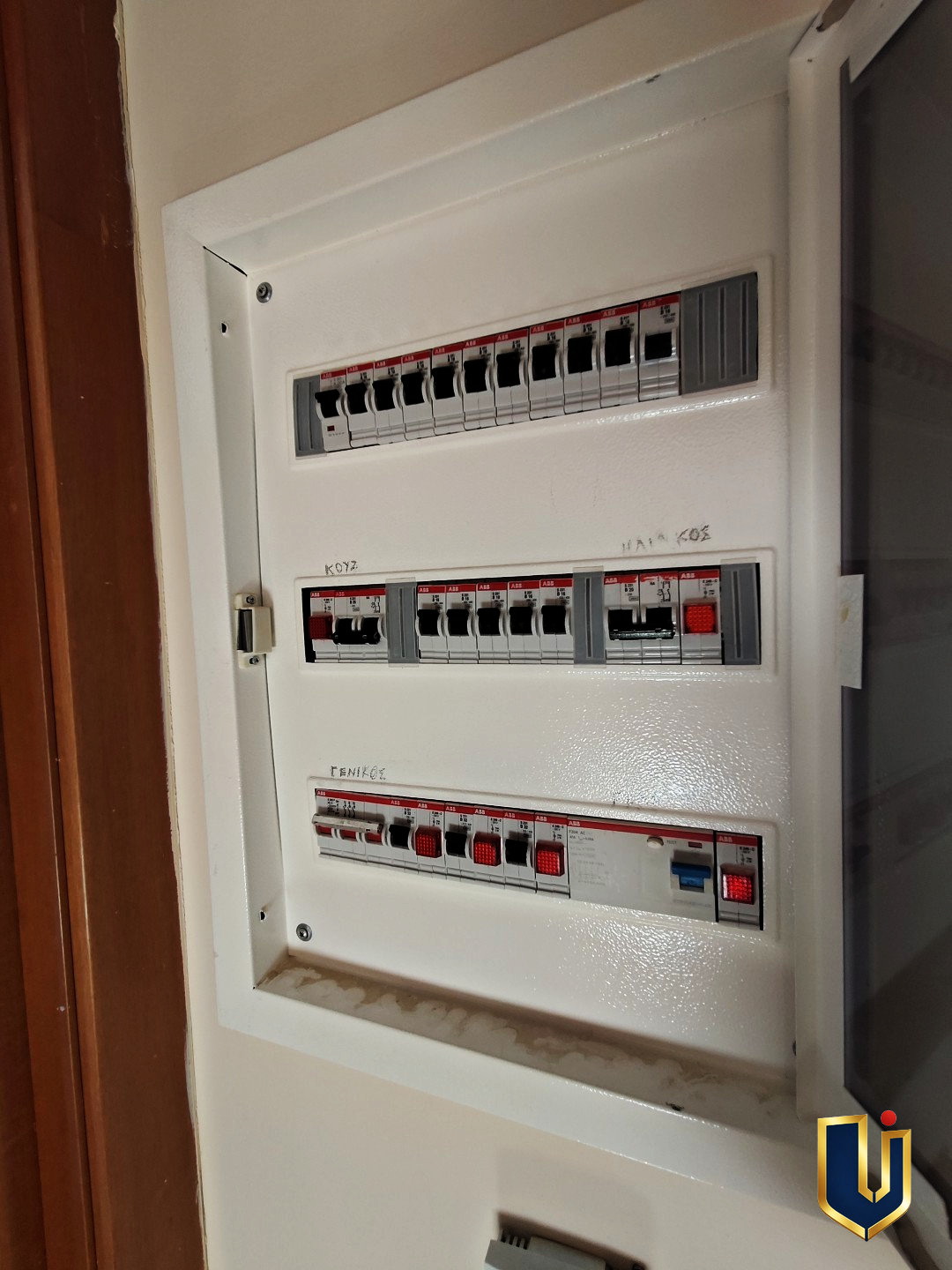 Wall-mounted electrical distribution panel with three rows of circuit breakers in a Paiania apartment