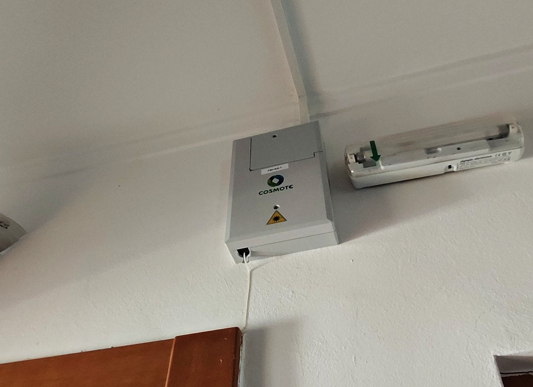 Fibre-optic connection box and cable conduit mounted above a doorway in a Paiania apartment