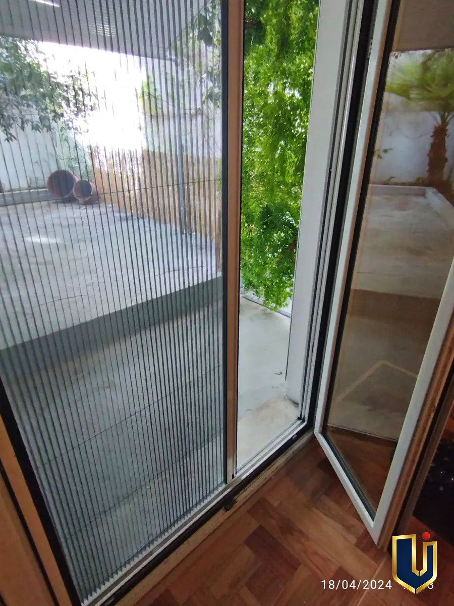 Double-leaf aluminium door with double glazing and an insect screen, opening onto the garden