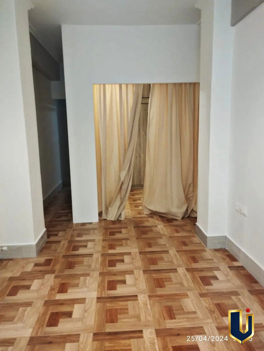 Interior view of the apartment from the balcony doorway, showing parquet flooring