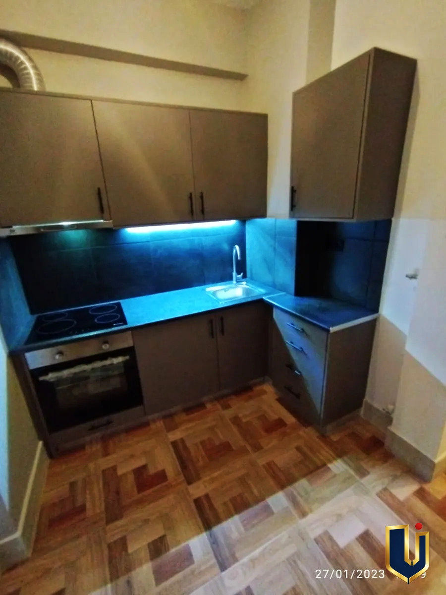 Renovated kitchen with dark cabinets and under-cabinet lighting in an apartment in Ano Patisia, Athens