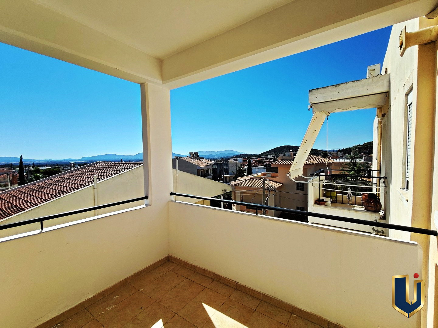 Covered balcony with open views over Paiania rooftops and distant mountains, East Attica, Greece