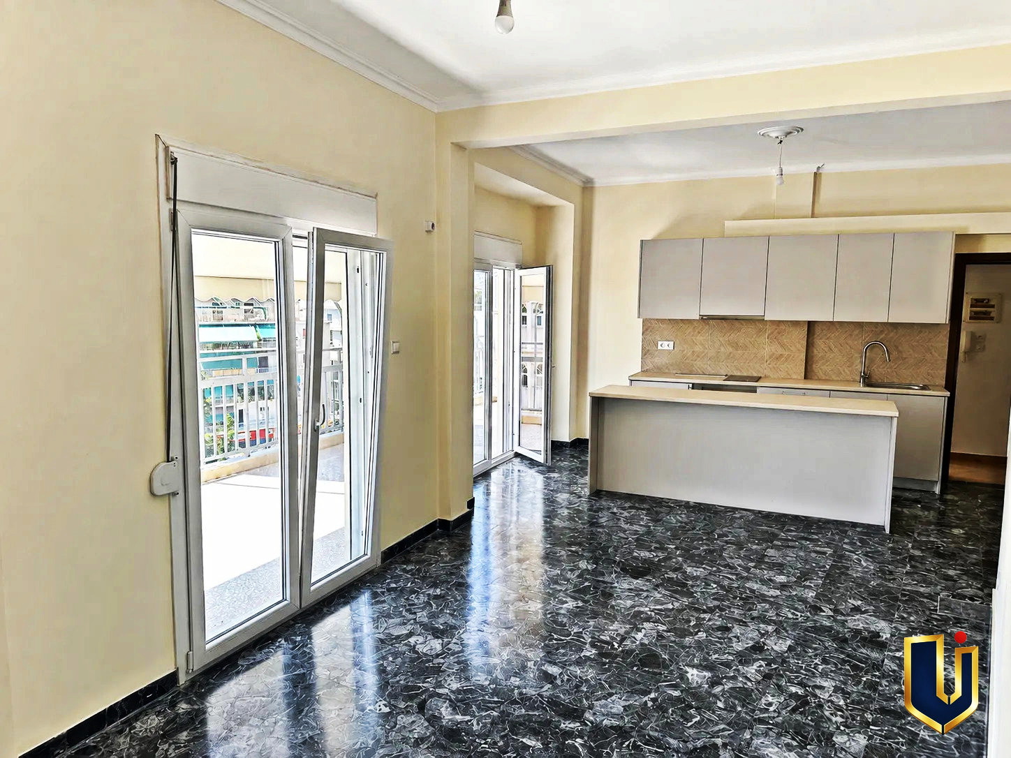 Renovated Kitchen with Balcony Access in Kato Patissia | Urban Keys Real Estate Renovated kitchen with a dark countertop and balcony doors in a penthouse in Kato Patissia, Athens.