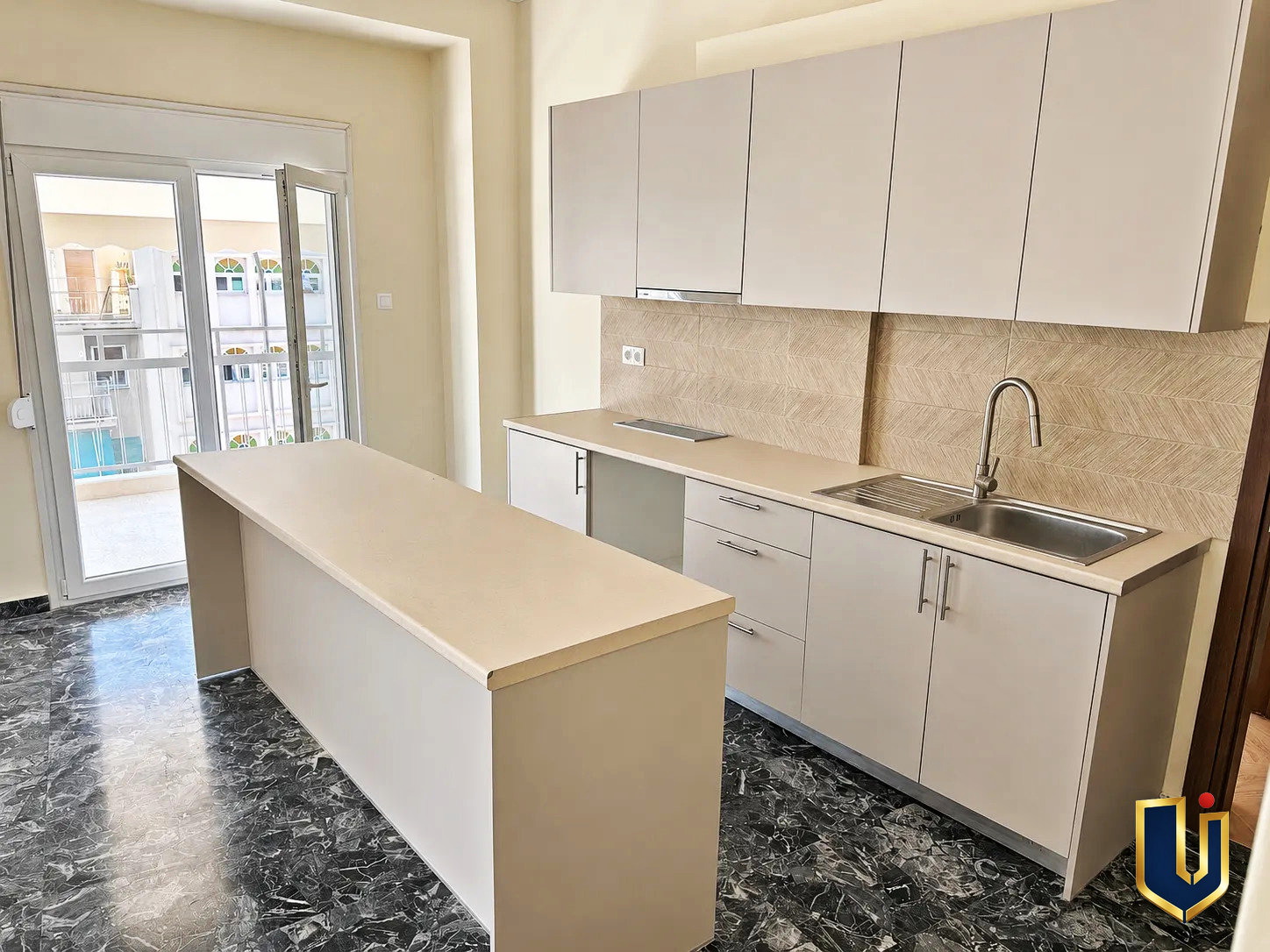 Modern Kitchen in Kato Patissia Penthouse | Urban Keys Real Estate Modern kitchen with white cabinets and a central island in a renovated penthouse in Kato Patissia, Athens.