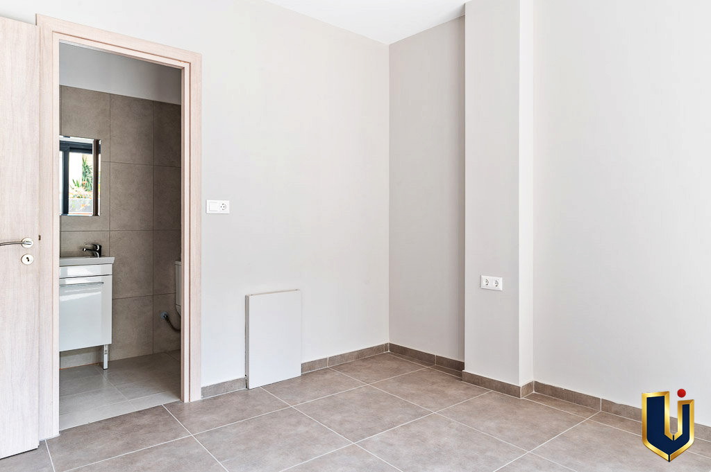 Apartment interior with an open bathroom doorway and light wood flooring, property 150-1075 in Athens.