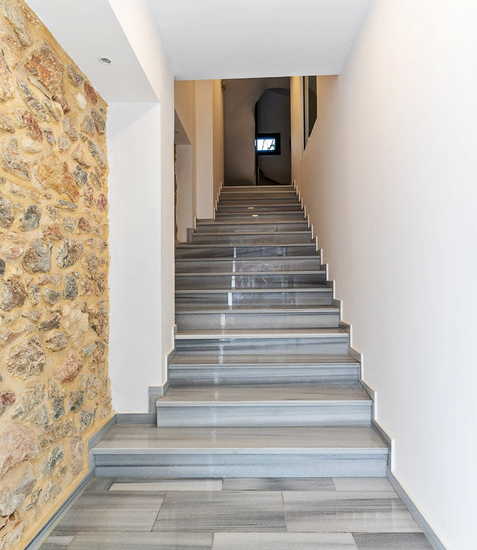 Interior staircase with a marble wall in the Urban Keys Athens building, property 150-1075.