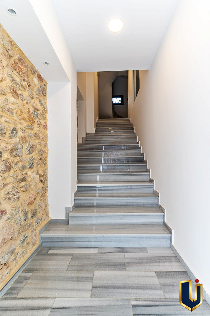 Interior staircase with a marble wall in the Urban Keys Athens building, property 150-1075.