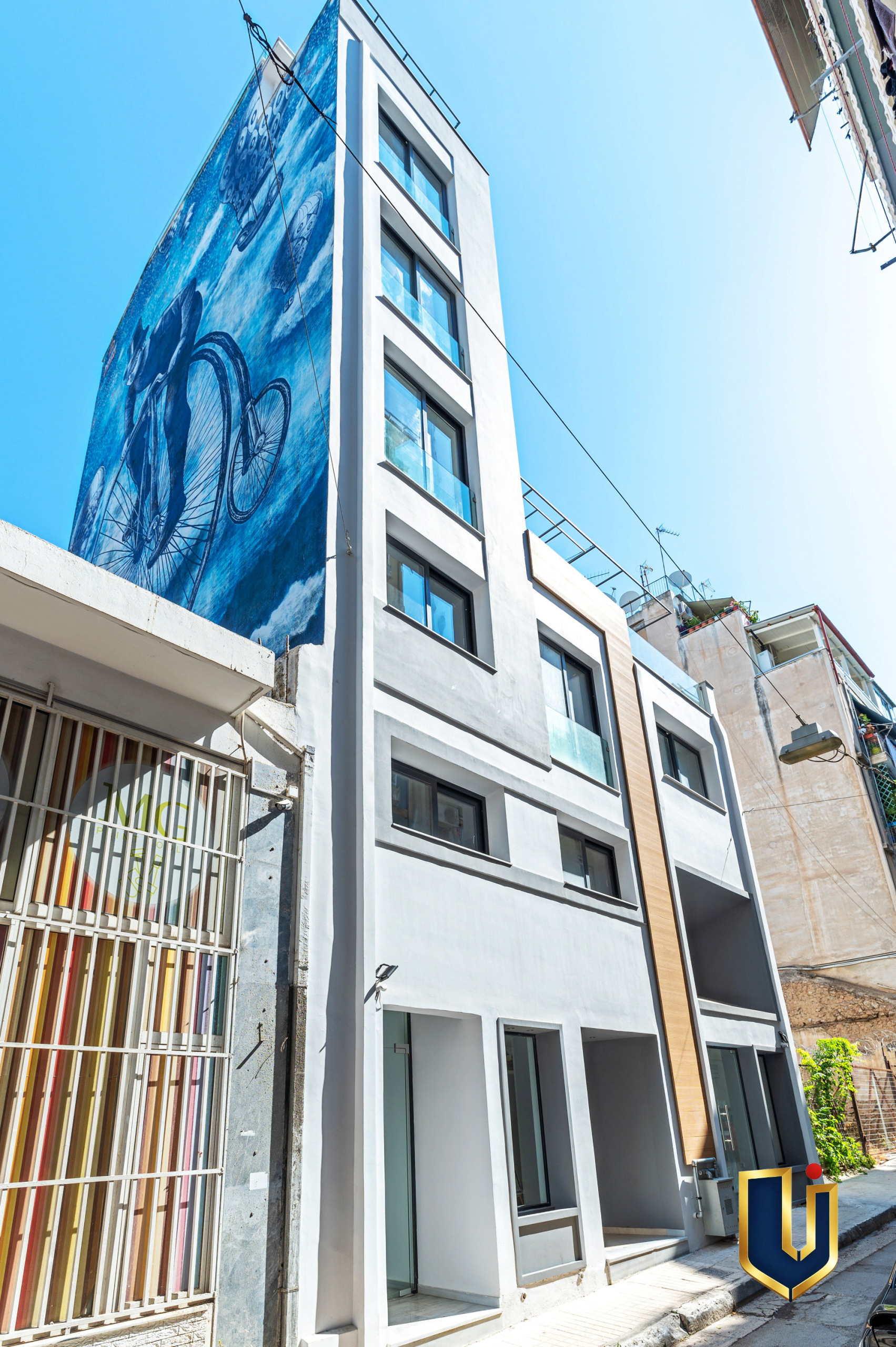 Modern white facade of an Athens investment building with balconies and a vertical wood-look panel, property 150-1075.