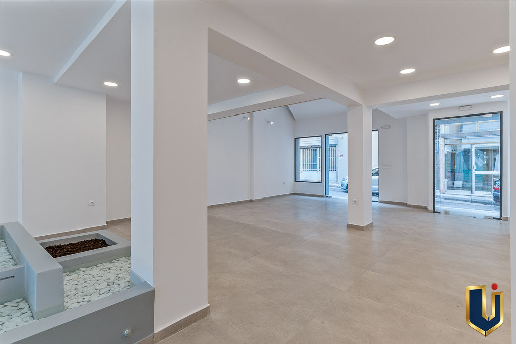 Open-plan ground-floor interior with structural columns and large glazed openings in the Athens investment building, property 150-1075.