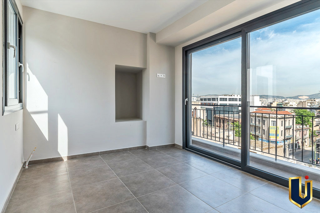 Bright apartment interior with glazed balcony doors overlooking the Athens cityscape, property 150-1075.